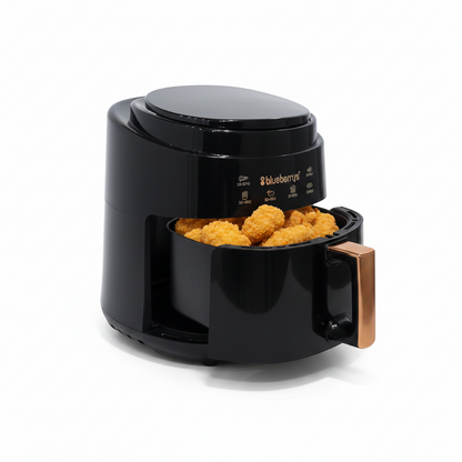 Black air fryer with fried food inside on a white background